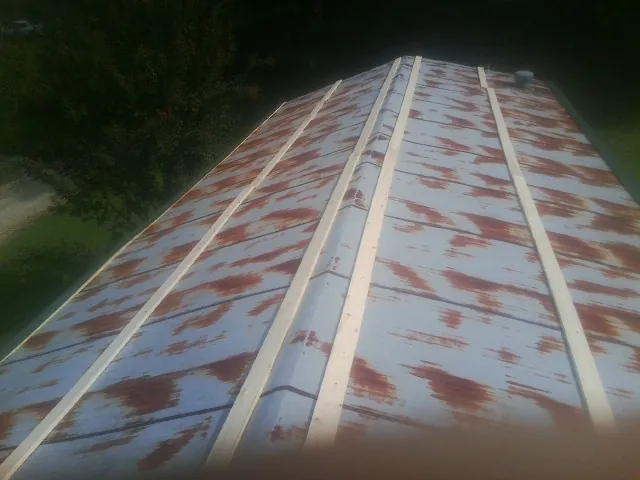 Rusted metal roof panels with new wood purlins before replacement — Storm Damage Roof Repair in Lindsey by Roofing Brothers